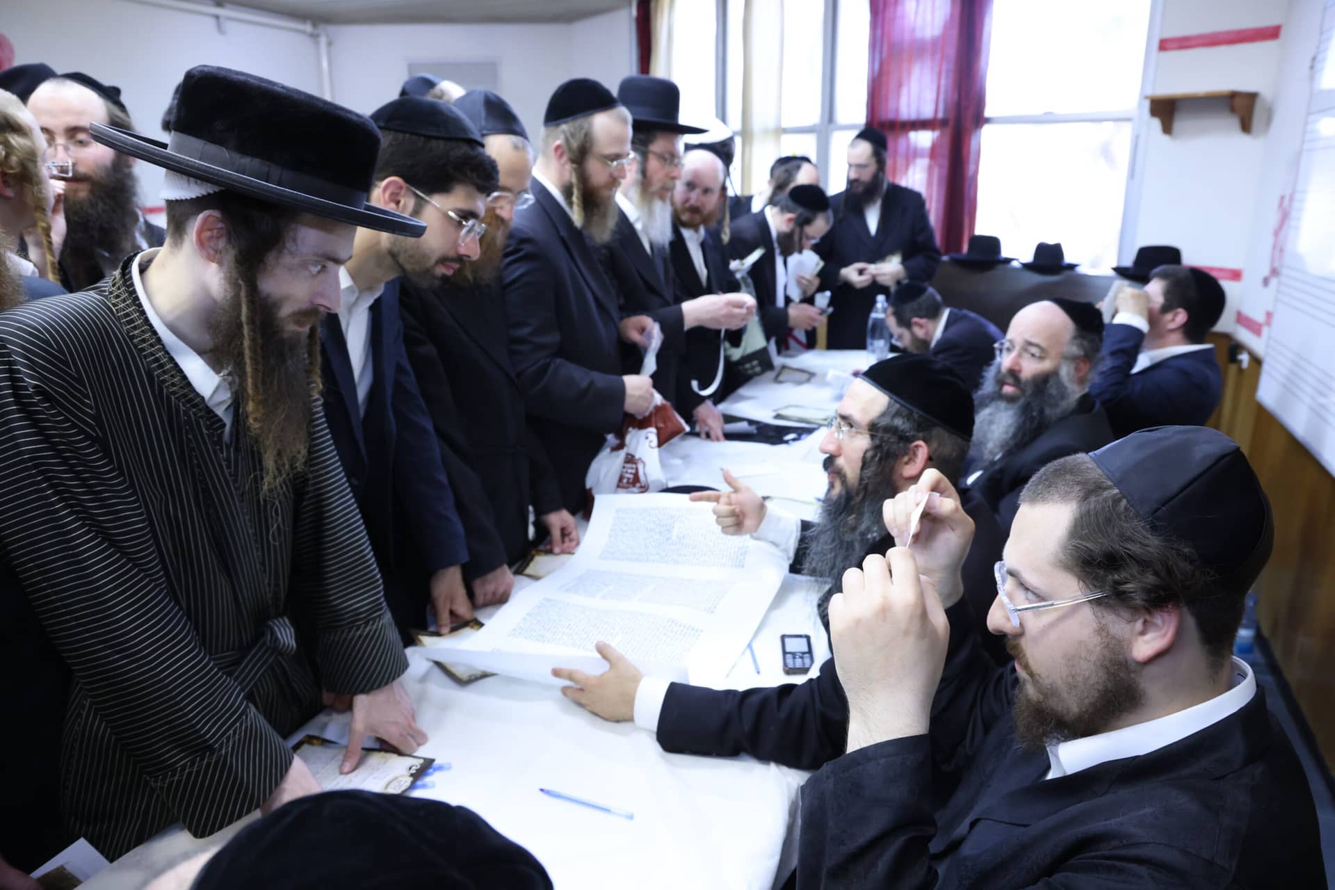 Rabbonim of the Vaad Mishmeres Sta"m examining a Sefer Torah